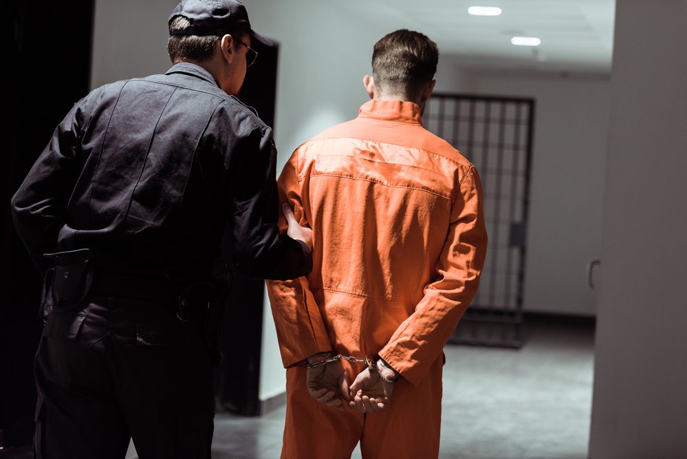 Rear view of the main prisoner handcuffed in the corridor