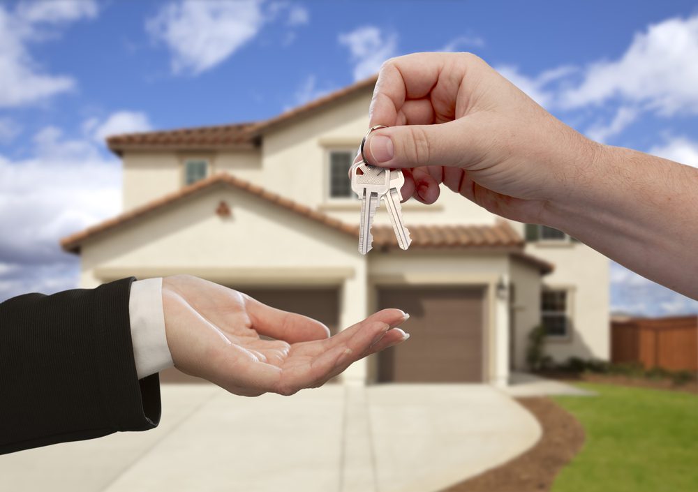 Entregando las llaves de la casa frente a un nuevo hogar